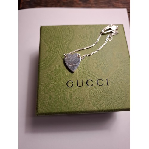34 - Gucci- A fine Sterling silver chain bracelet with heart pendant, made in Italy having a branded dust... 