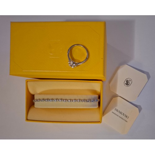 35 - Swarovski- A silver tone adjustable bracelet with 40 white crystals having a branded box and care bo... 