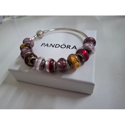 33 - Pandora & Lovebeads- A silver charm bracelet with 11 compatible (not Pandora) coloured glass bead ch... 
