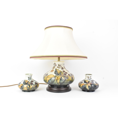 A Moorcroft pottery 'Bramble' pattern table lamp and pair of matching vases, each of squat baluster form, tube lined with berries and leaves, incised and painted marks to the bases, the lamp excluding light fitting 18.5cm high x 20cm wide, the vases 10.5cm high x 12.5cm wide
Location: RAB
If there is no condition report shown, please request