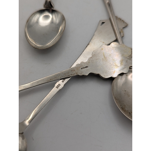 28 - 7 assorted 800 grade silver collectors' spoons with enamel decoration to the terminals, total weight... 