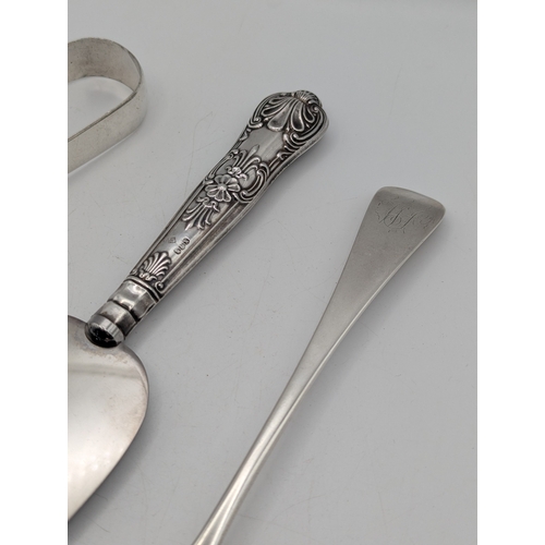 29 - Silver to include a pair of sugar tongs, a tablespoon and three collectors' spoons, total weight 145... 