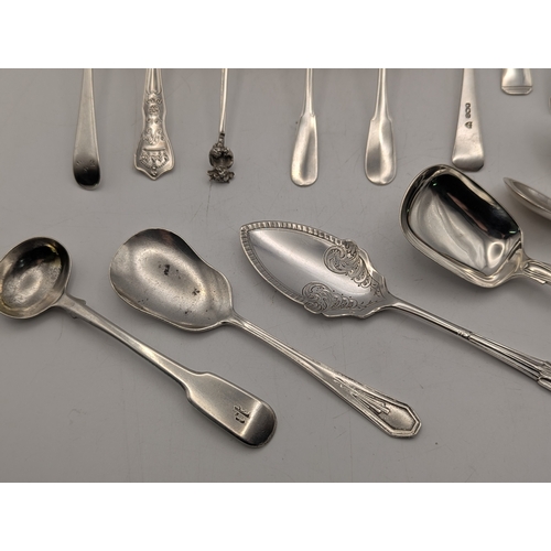 30 - An assortment of silver teaspoons some with engraved initials along with butter knives and other flo... 