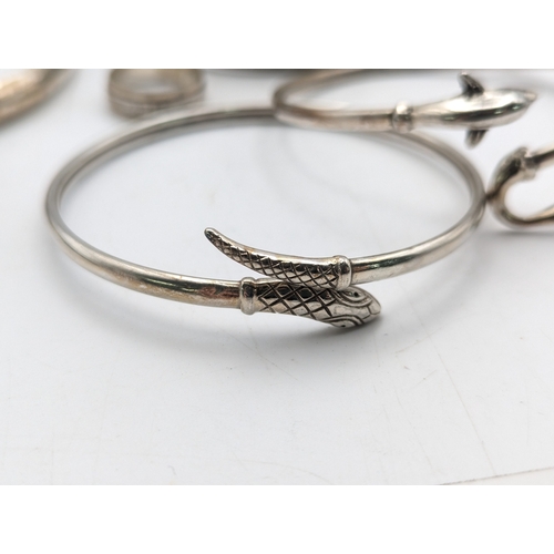 33 - A collection of silver bangles to include examples from Mexico, a Navajo style cuff bracelet set wit... 