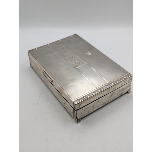 6 - A silver cigarette box having engine turned engraving on the lid and decorative relief borders with ... 