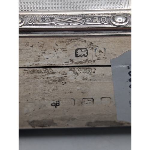 6 - A silver cigarette box having engine turned engraving on the lid and decorative relief borders with ... 
