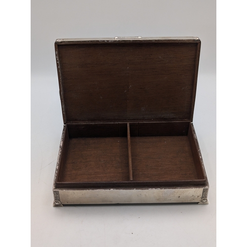 6 - A silver cigarette box having engine turned engraving on the lid and decorative relief borders with ... 