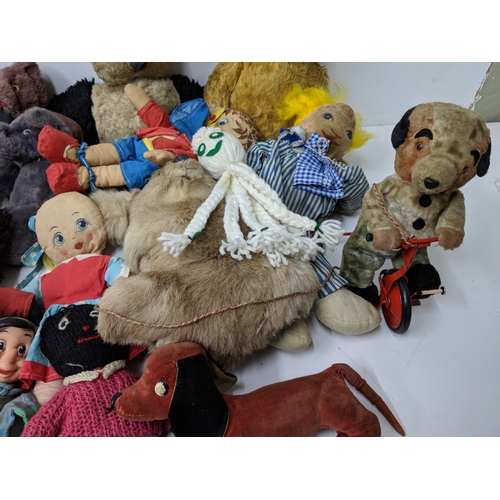 12 - Assorted soft toys and bears to include Golly dolls, a pull along dog on a bike, soft toys some fash... 