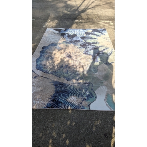 59 - A modern machine woven carpet having a blue and cream psychedelic design, 199cm x 303cm
Location: A3... 