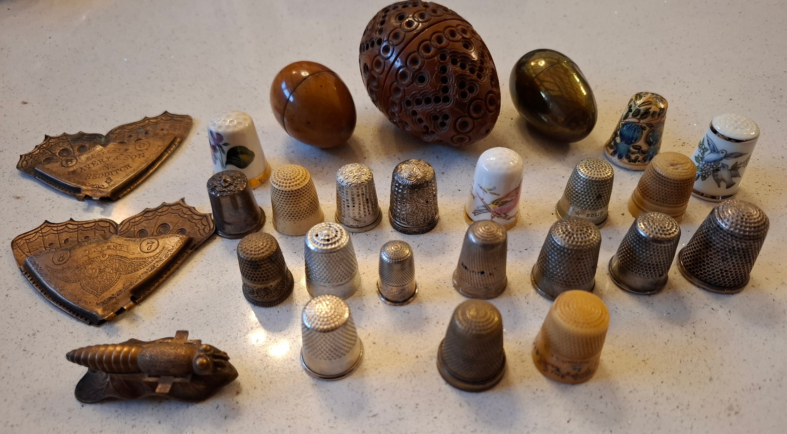 A collection of thimbles, thimble cases, a Victorian carved coquilla ...