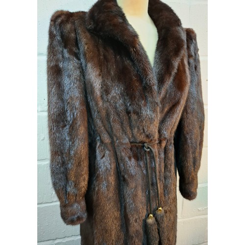 32 - A 1980's very dark brown mink fur coat, appears black in certain lighting, having a black toggle tie... 