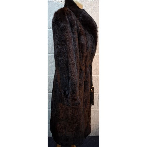 32 - A 1980's very dark brown mink fur coat, appears black in certain lighting, having a black toggle tie... 