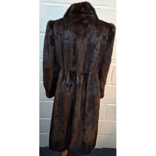 32 - A 1980's very dark brown mink fur coat, appears black in certain lighting, having a black toggle tie... 