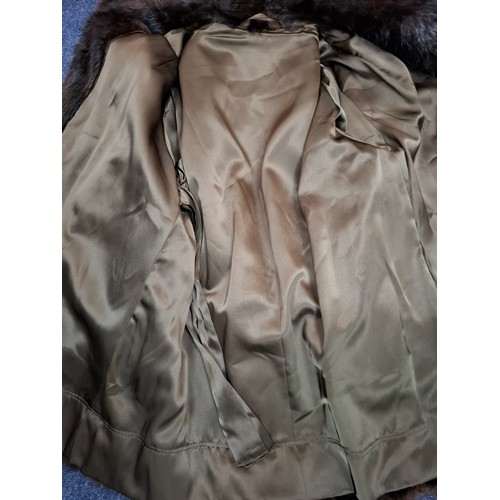 26 - A late 20th Century very dark brown and black striped mink coat with matching belt and brown satin l... 