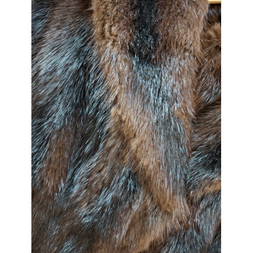 26 - A late 20th Century very dark brown and black striped mink coat with matching belt and brown satin l... 