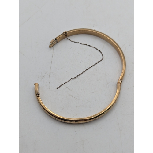 16 - A 9ct yellow gold bracelet with floral scroll engraved decoration and box link clasp and safety chai... 