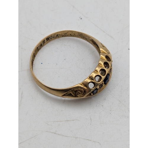 32 - A sapphire and diamond 18ct yellow gold boat ring featuring three old cut blue sapphires and two sma... 