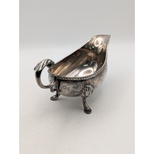 34 - A silver sauce boat with beaded rim and scroll handle on three feet hallmarked Birmingham 1979, weig... 