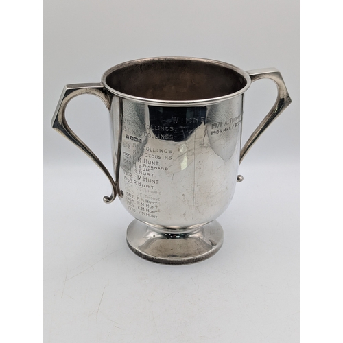 47 - A silver trophy cup with twin handles on pedestal foot and gilded interior and engraved inscription ... 