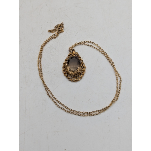 51 - A 9ct yellow gold teardrop shaped pendant with claw set oval faceted cut smoky quartz on a fine 9ct ... 
