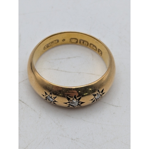 60 - An 18ct yellow gold and three stone diamond starburst gypsy ring stamped 18ct with British hallmarks... 