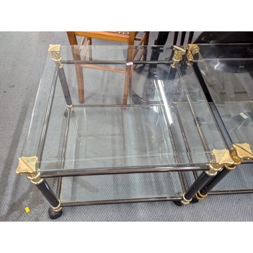 A pair modern glass two tier occasional tables supported by Corinthian ...