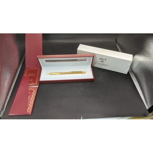 10 - A boxed cartier Santos Sans a Graffe gold plated ballpoint pen with certificate and user guide
Locat... 