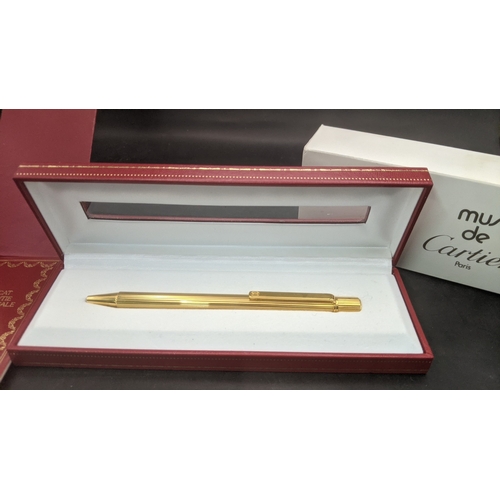 10 - A boxed cartier Santos Sans a Graffe gold plated ballpoint pen with certificate and user guide
Locat... 