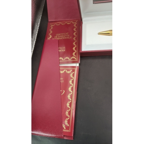 10 - A boxed cartier Santos Sans a Graffe gold plated ballpoint pen with certificate and user guide
Locat... 