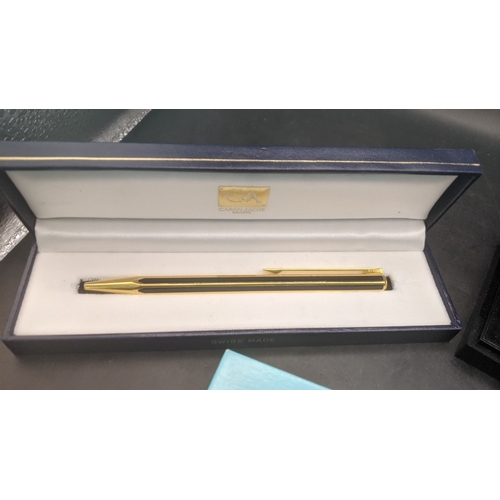 12 - Boxed writing equipment to include a Caran D'ache gold plated ballpoint pen, an Yves Saint Laurent c... 