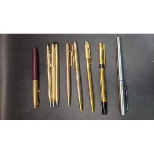 13 - A collection of unboxed writing equipment to include three gold plated Cross ballpoint pens, a burgu... 