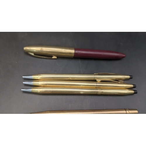 13 - A collection of unboxed writing equipment to include three gold plated Cross ballpoint pens, a burgu... 