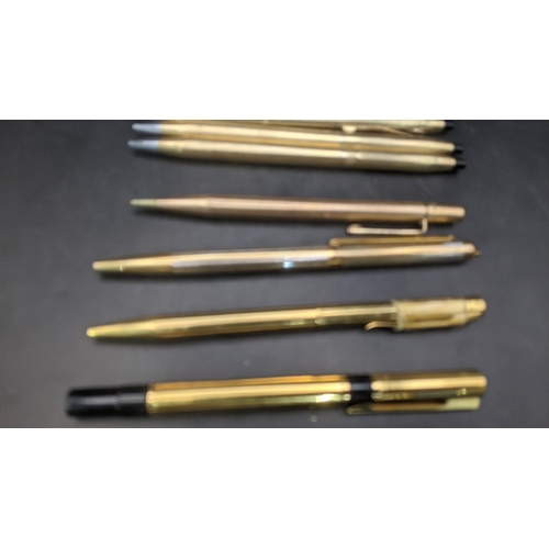 13 - A collection of unboxed writing equipment to include three gold plated Cross ballpoint pens, a burgu... 