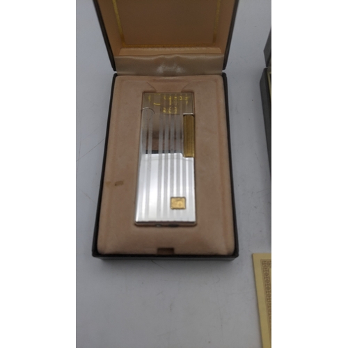 25 - Boxed cigarette lighters to include a gold plated Dunhill Rollagas lighter along with a silver plate... 