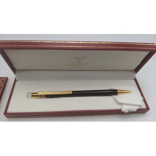 39 - A boxed Must de Cartier Trinity ballpoint pen with a black lacquer body with guarantees and user gui... 