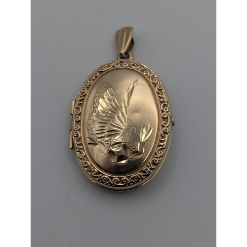 10 - A 9ct yellow gold oval shaped locket with engraved decoration to the centre depicting a butterfly an... 
