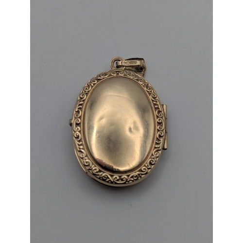 10 - A 9ct yellow gold oval shaped locket with engraved decoration to the centre depicting a butterfly an... 