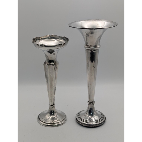 23 - Two silver vases both having tapered columns on circular stepped weighted bases, one 20cm h and the ... 