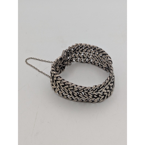 32 - A Mexican silver double curb link woven thick gauge bracelet with box link clasp and safety chain, w... 