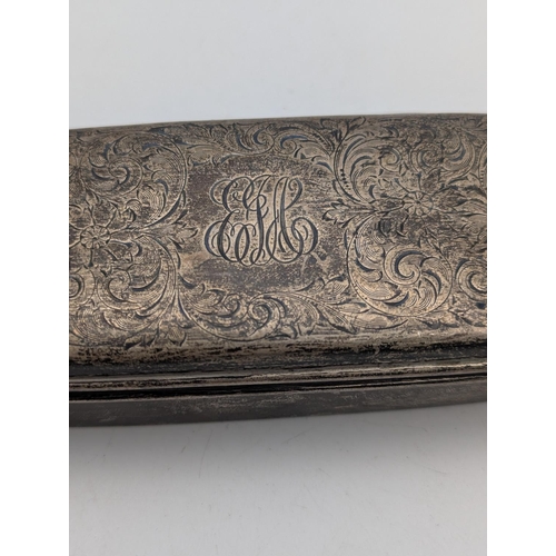 34 - A sterling silver tobacco box in oblong form, floral scroll engraved decoration with initials to the... 