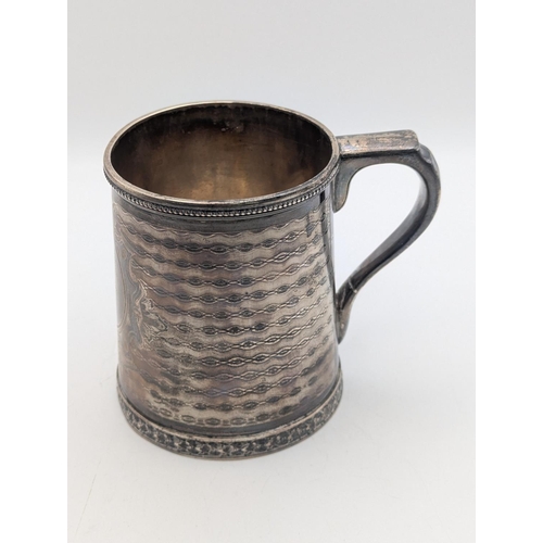 35 - A sterling silver tankard by Tiffany and Co having engine turned decoration with central multi-layer... 