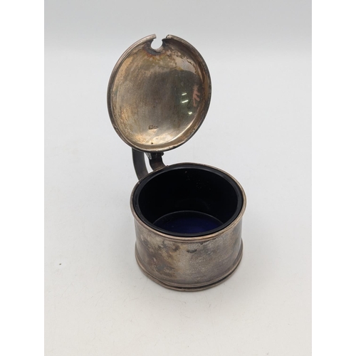 51 - A George V silver mustard pot with hinged lid and blue glass liner, total weight excluding glass 40.... 