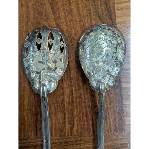 54 - A pair of Victorian salad servers with floral engraved decoration to the base of the bowls and termi... 