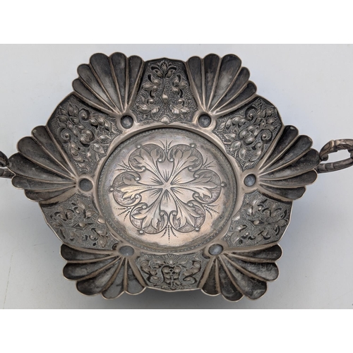 55 - A silver bon bon dish in hexagonal form, shell shaped and floral embossed panels and scalloped borde... 