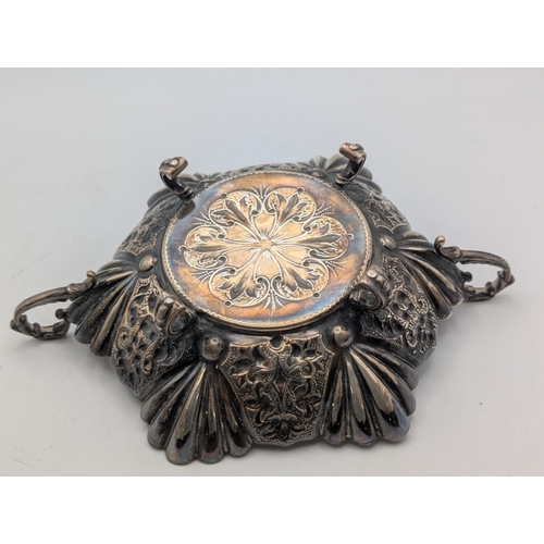 55 - A silver bon bon dish in hexagonal form, shell shaped and floral embossed panels and scalloped borde... 