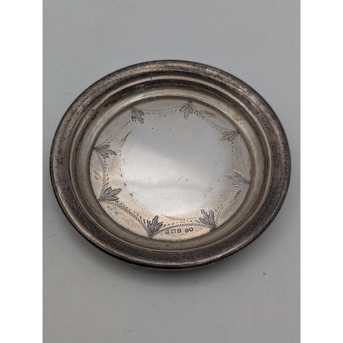 56 - A silver pin dish with stepped rim and repeating engraved decoration 43.4g together with a silver fi... 
