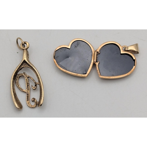 9 - Two 9ct yellow gold pendants to include a wishbone pendant with scroll engraved decoration mounted w... 