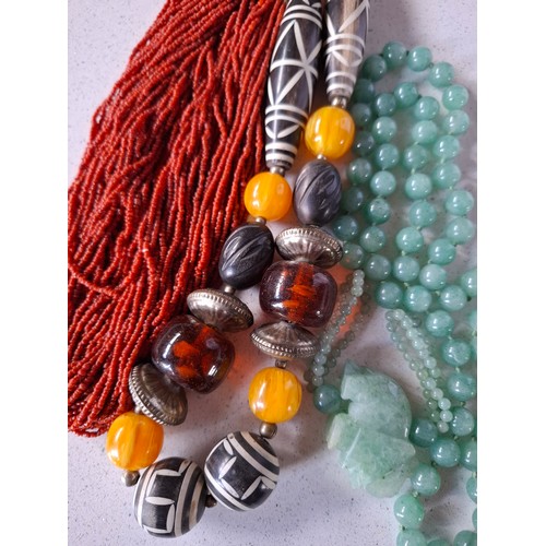 37 - Vintage necklaces to include an ethnic amber coloured bead necklace, a coral multi strand necklace a... 