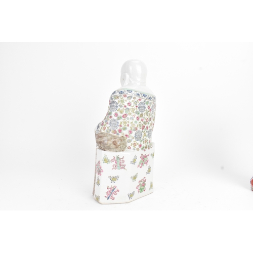 14 - A Chinese famille rose porcelain model of a Buddha, seated holding a beaded necklace, his robe decor... 