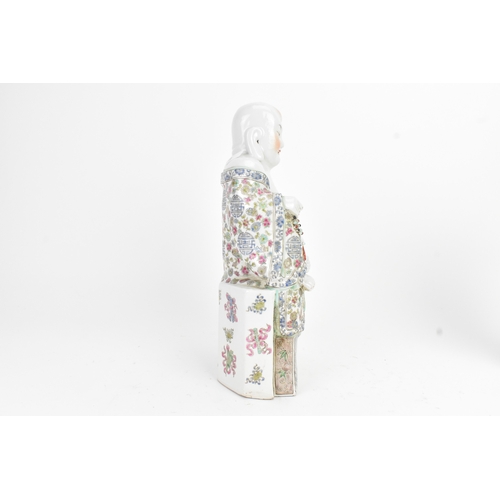 14 - A Chinese famille rose porcelain model of a Buddha, seated holding a beaded necklace, his robe decor... 